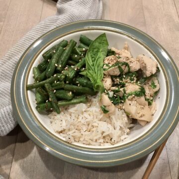 Chile, Basil & Chicken Stir-fry served in a bowl with a towel and chop sticks