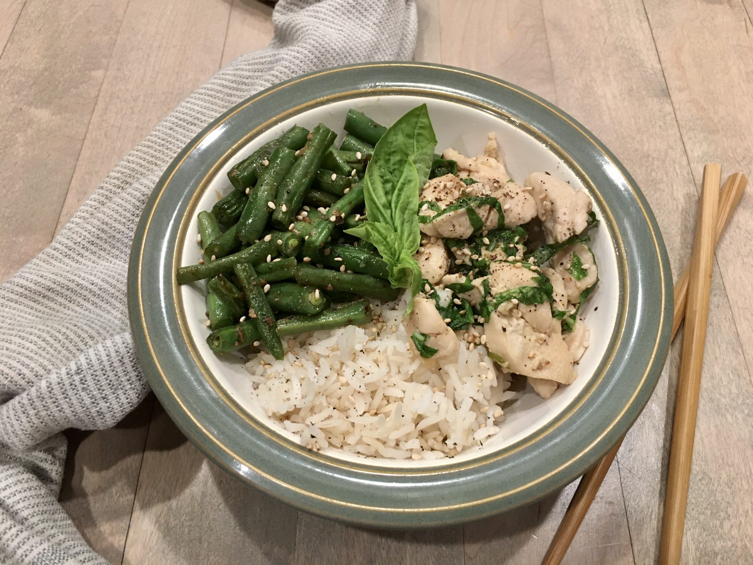 Chile, Basil & Chicken Stir-fry served in a bowl with a towel and chop sticks