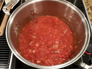 Large pot over stove with tomato soup