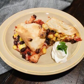 Mexican Pizza Pie cut into slices and placed on top of a tan plate