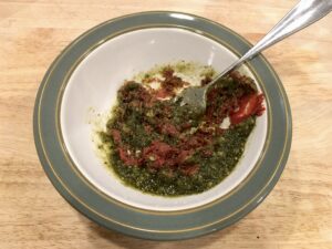 Single piece of sourdough pizza on a tan plate - Tomato Paste & Pesto